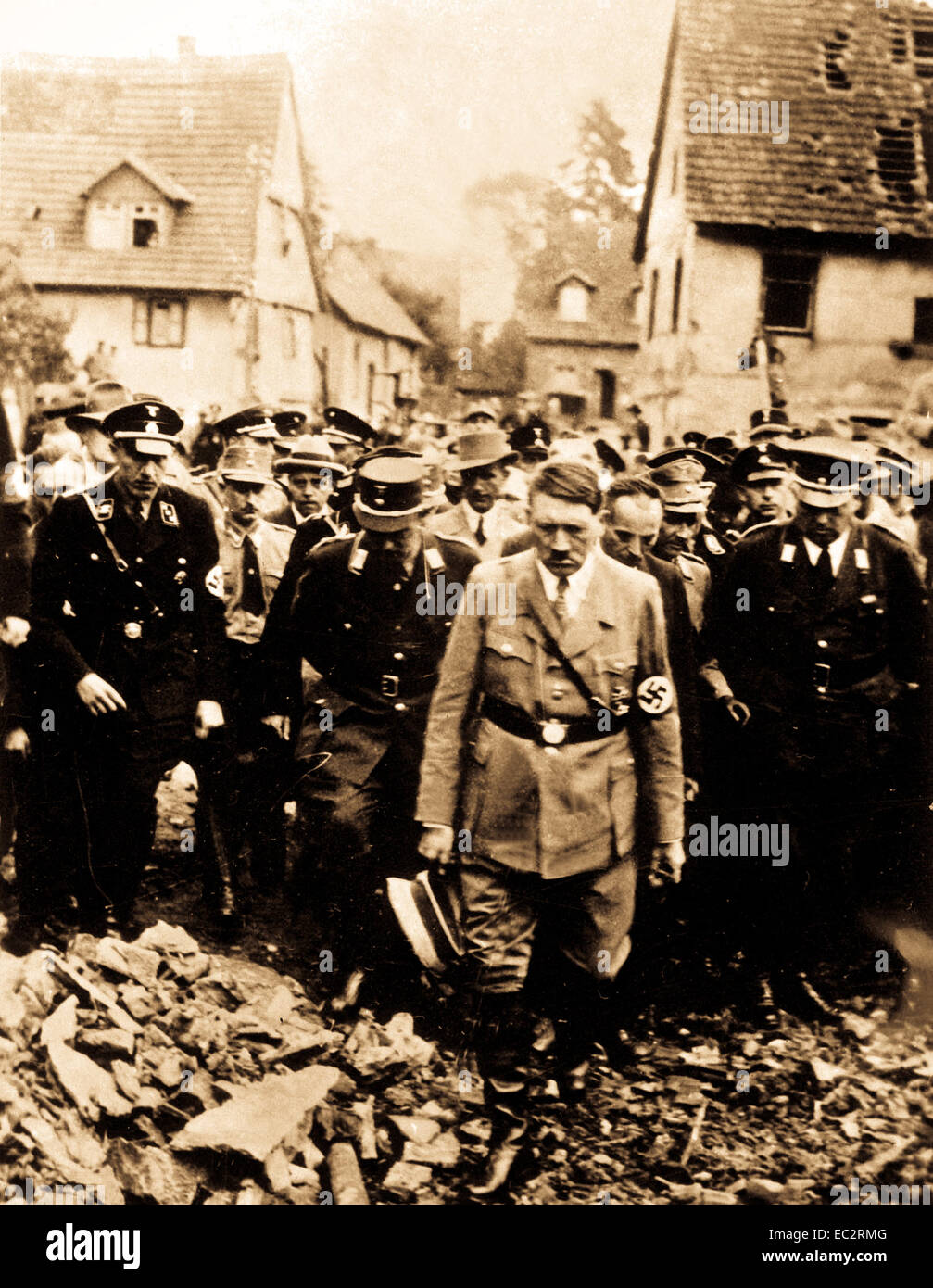 Adolf Hitler, accompanied by other German officials, grimly inspects bomb damage in a German city in 1944, in this German film captured by the U.S. Army Signal Corps on the western front. Ca. 1944.  (Army) Stock Photo