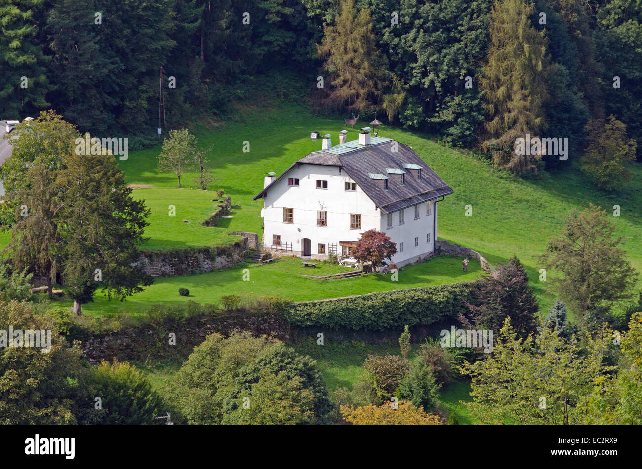 White house in Alps landscape on green grass lawn. Stock Photo
