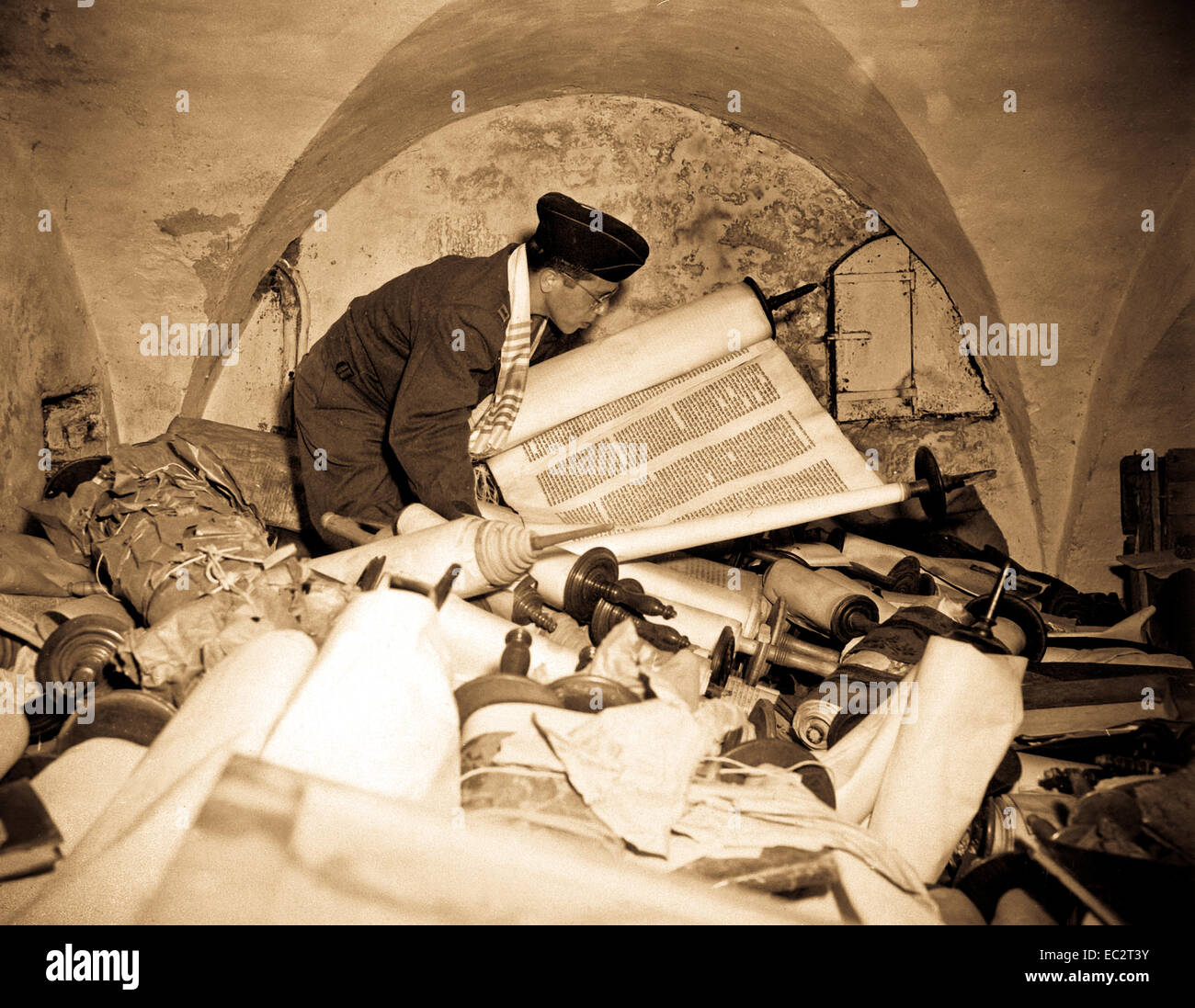 In the cellar of the Race Institue in Frankfrut, Germany, Chaplain Samuel Blinder examines one of hundreds of 'Saphor Torahs' (Sacred Scrolls), among the books stolen from every occupied country in Europe.  July 6, 1945.  T3c. Irving Katz. (Army) Stock Photo