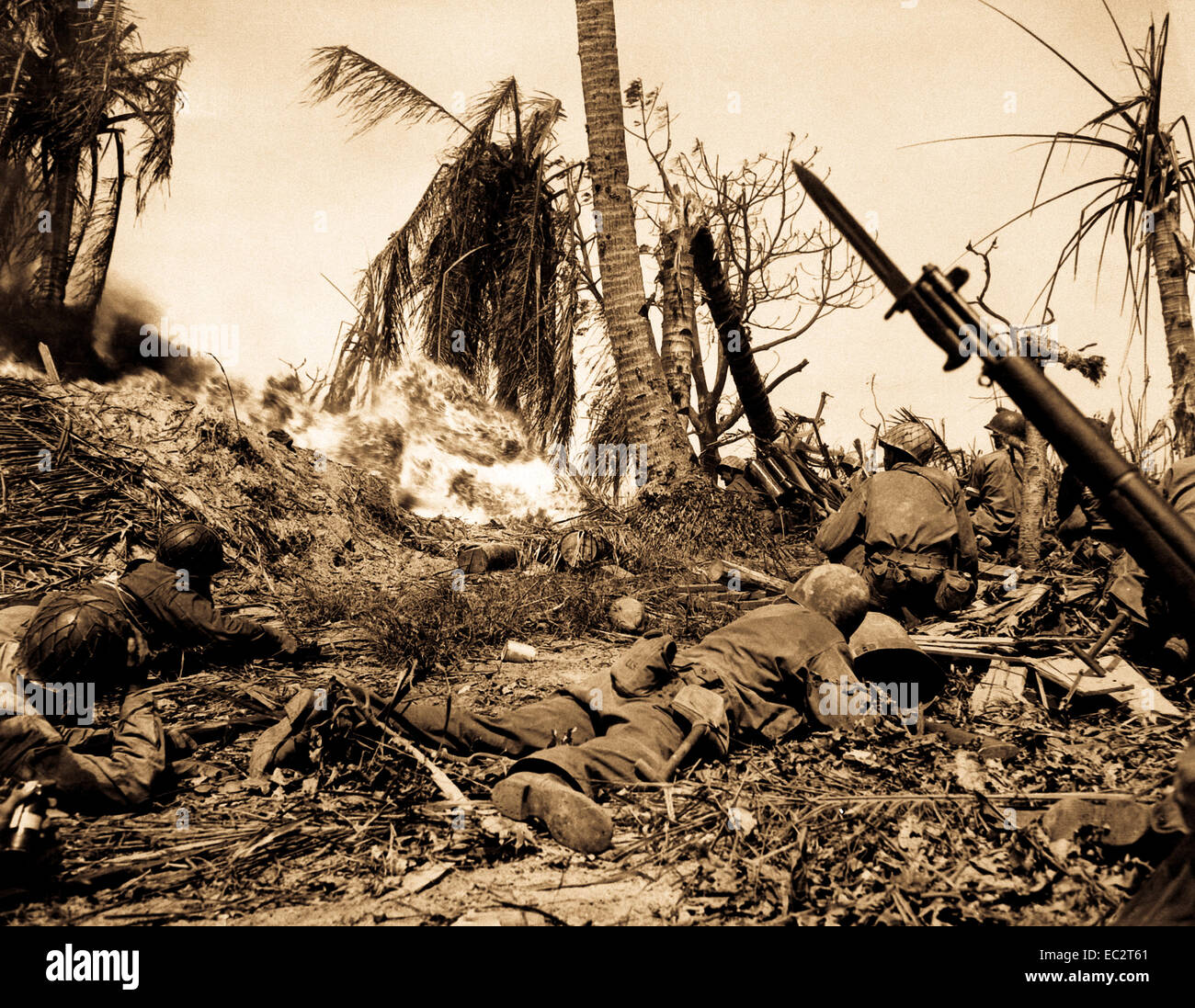 Men of the 7th Div. using flame throwers to smoke out Japanese from a block house on Kwajalein Island, while others wait with rifles ready in case Japs come out. February 4, 1944.  Cordray. (Army) Stock Photo