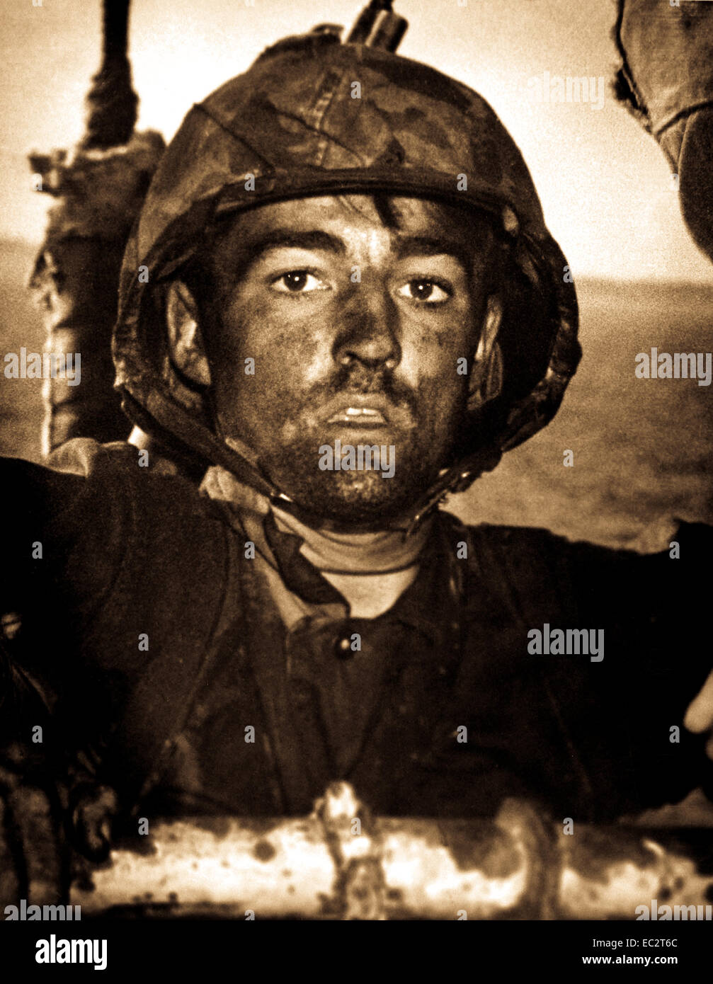 Back to a Coast Guard assault transport comes this Marine after two days and nights of Hell on the beach of Eniwetok in the Marshall Islands.  His face is grimey with coral dust but the light of battle stays in his eyes.  February 1944. (Coast Guard) Stock Photo