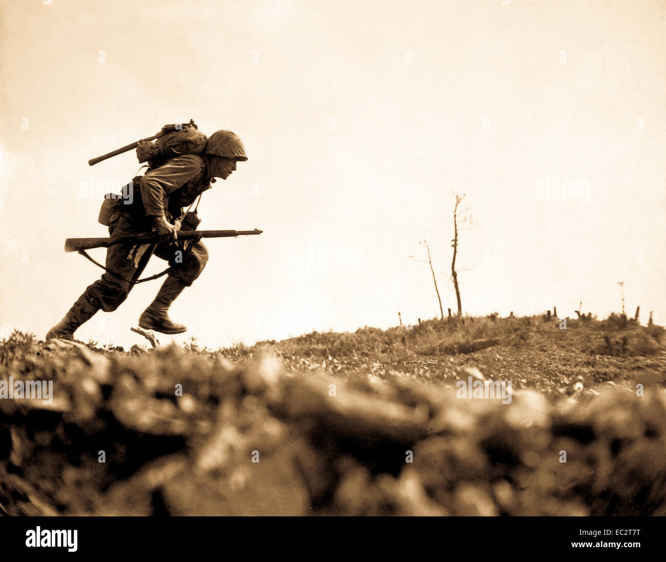 A Marine dashes through Japanese machine gun fire while crossing a draw, called Death Valley by the men fighting there.  Marines sustained more than 125 casualties in eight hours crossing this valley.  Okinawa, May 10, 1945.  Pvt. Bob Bailey.  (Marine Corps) Stock Photo