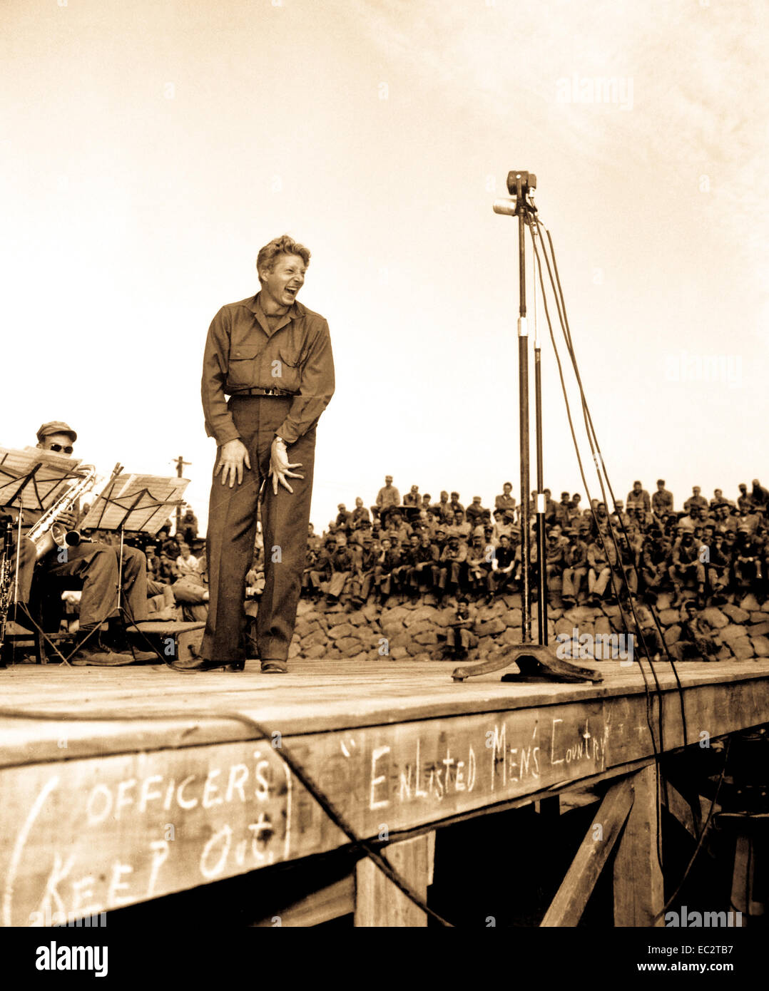 Danny Kaye, well  known stage and screen star, entertains 4,000 5th Marine Div. occupation troops at Sasebo, Japan.  The crude sign across the front of the stage says: 'Officers keep out!  Enlisted men's country.' Stock Photo