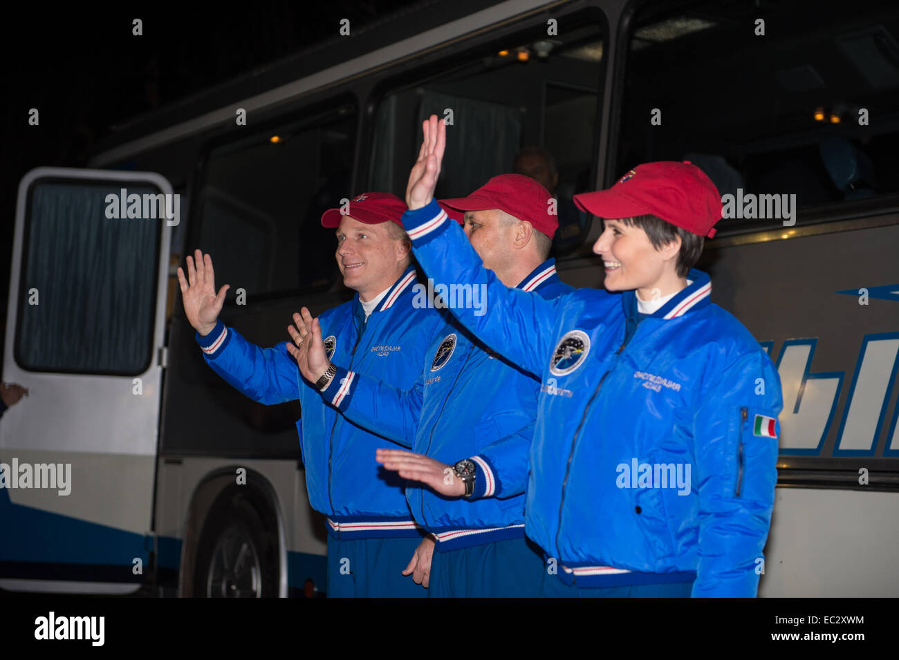 Expedition 42 crew members, Flight Engineer Terry Virts of NASA, left, Soyuz Commander Anton Shkaplerov of the Russian Federal Space Agency (Roscosmos), center,  and Flight Engineer Samantha Cristoforetti of the European Space Agency (ESA), right, wave farewell to family and friends as they depart the Cosmonaut Hotel to suit up for their Soyuz launch to the International Space Station on Sunday, Nov. 23, 2014, in Baikonur, Kazakhstan. Launch of the Soyuz rocket is scheduled for the early hours of Nov. 24 and will send Virts, Shkaplerov, and Cristoforetti on a five and a half month mission aboa Stock Photo