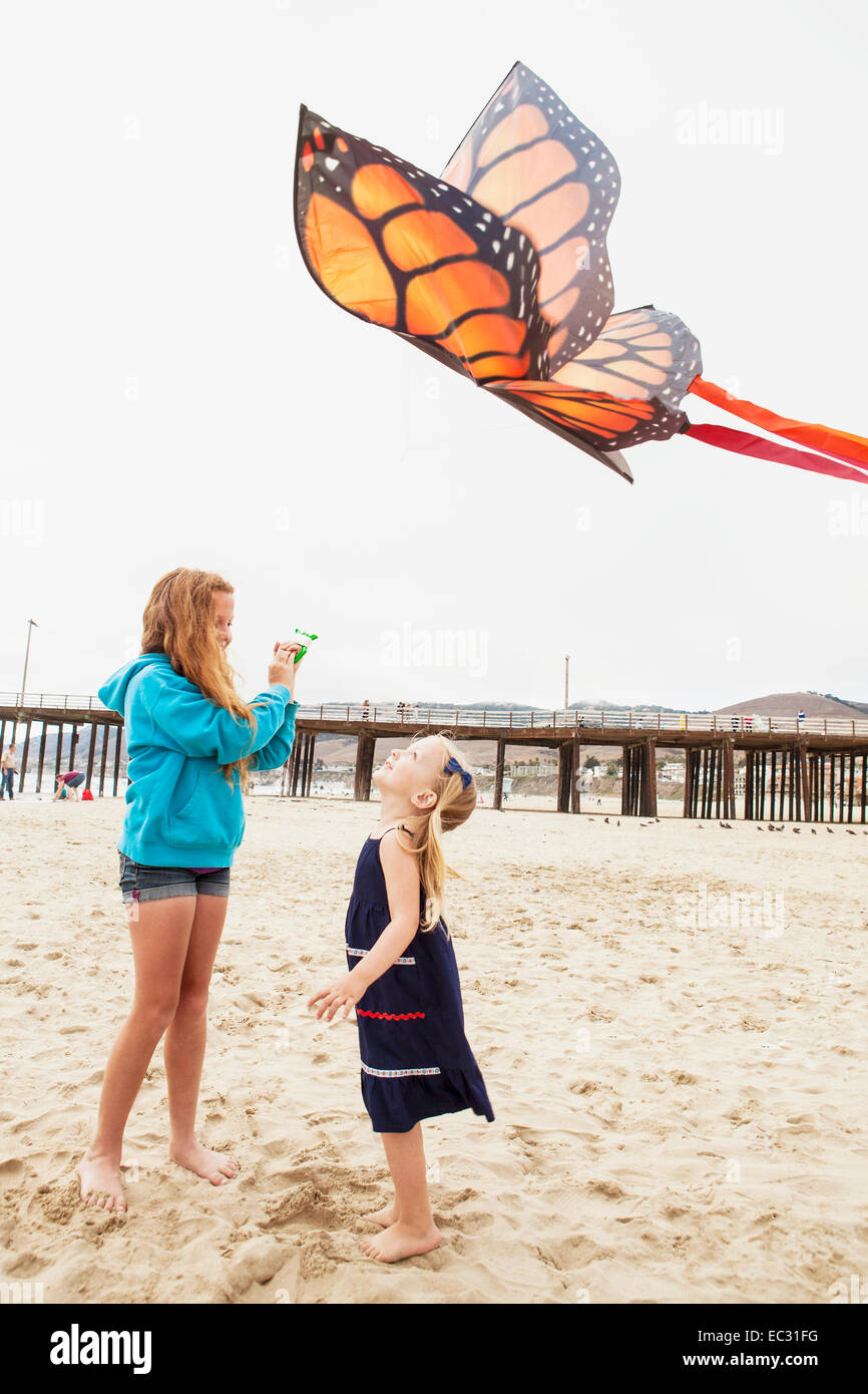 young girls flying a kite at the beach, Pismo Beach, Central Coast