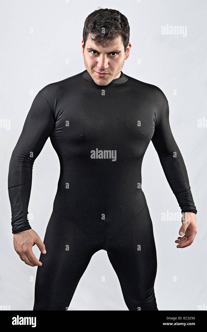 young male with black hair wearing tight fitting black body suit Stock Photo