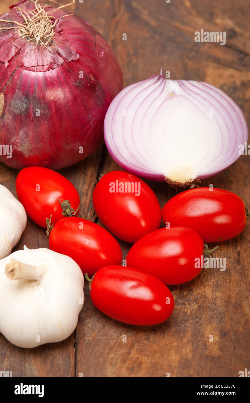 onion garlic and tomatoes foundations of Italian food on rustic table ...