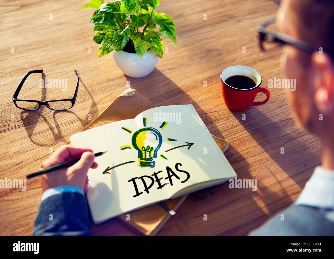 Man Writing Idea Concepts on His Note Stock Photo