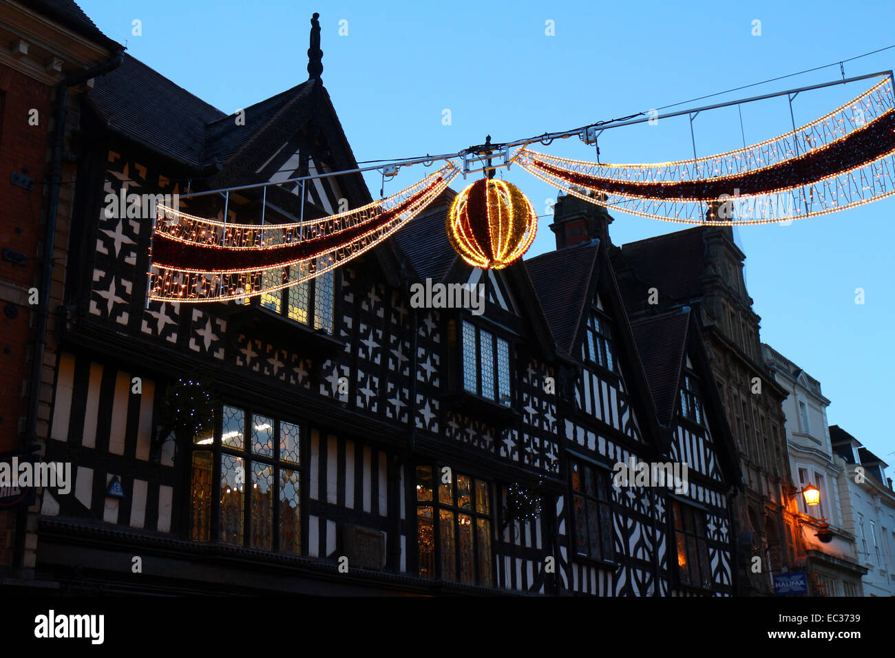 Shrewsbury, UK. 8th December, 2014. Christmas lights cross High Street, Shrewsbury, in front of historic black and white building facades as the town prepares for Christmas. In 1984, Shrewsbury was the location for a film adaptation of Charles Dickens' 'A Christmas Carol' starring George C. Scott as Scrooge. Credit:  John Gilbey/Alamy Live News Stock Photo