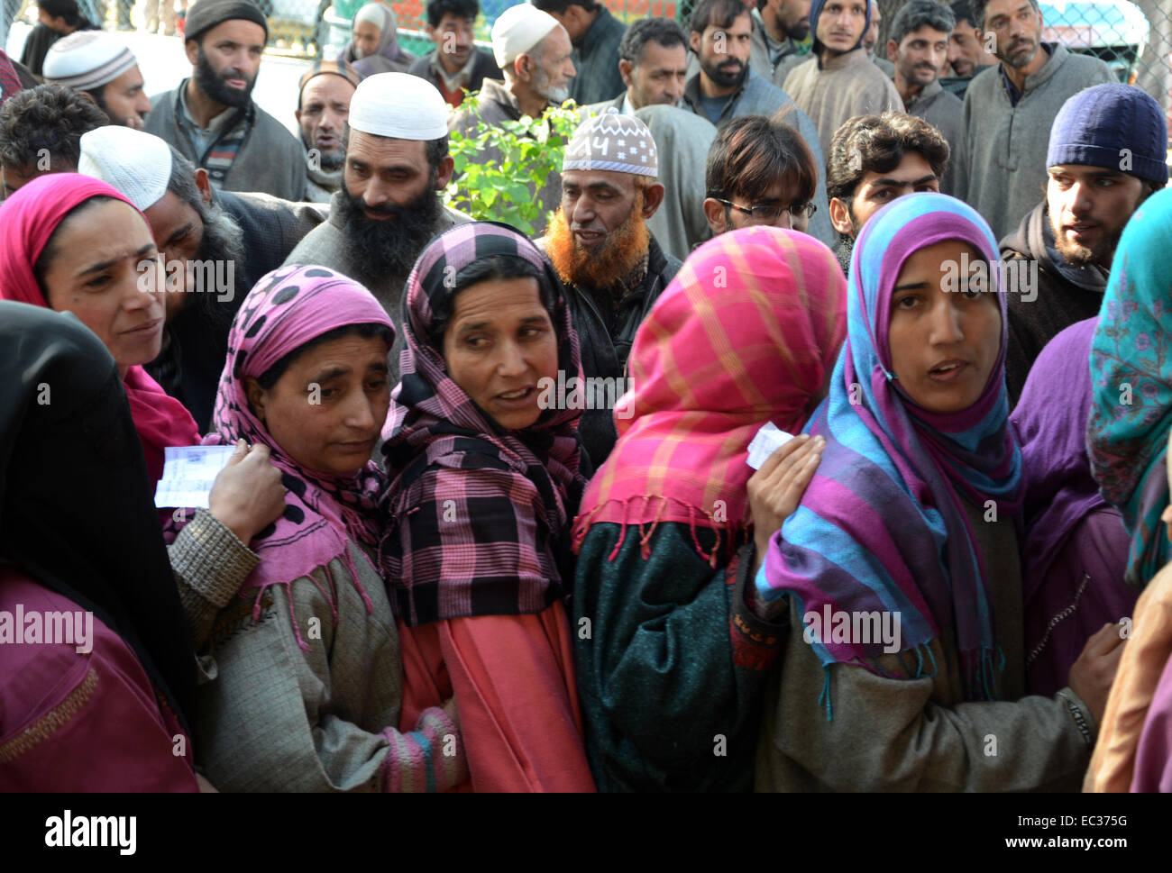 Srinagar, Indian Administered Kashmir. 9th December, 2014.  Kashmiri voters queue at a polling station inChrar-e-Sharief on the outskirts of Srinagar.India-administered Kashmir headed to the third phase of state assembly polls under tight security with Indian Prime Minister Narendra Modi's Hindu nationalist party eyeing power for the first time in the tense and disputed Muslim-majority state. Credit:  sofi suhail/Alamy Live News Stock Photo