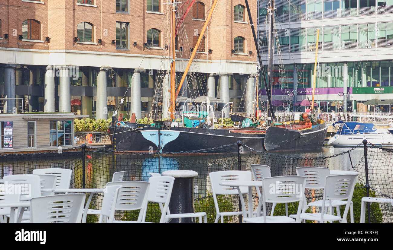 Outdoor seating boats and restaurants in upmarket St Katherine Docks marina east London England Europe Stock Photo