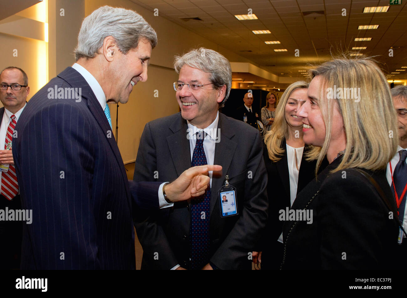 U.S. Secretary of State John Kerry chats with the new Foreign Minister of Italy, Paolo Gentiloni, after being introduced by European Union High Representative Federica Mogherini, the previous Italian Foreign Minister, between a series of multinational meetings on December 2, 2014, at NATO Headquarters in Brussels, Belgium. Stock Photo