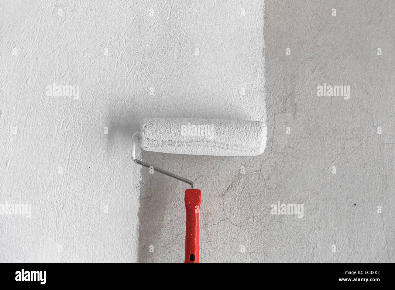 Painting a rough wall by painting roller. Stock Photo