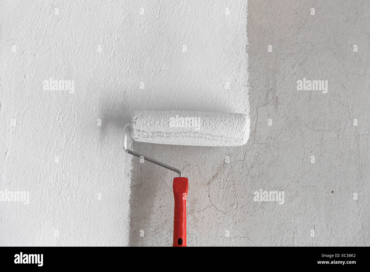 Painting a rough wall by painting roller Stock Photo Alamy