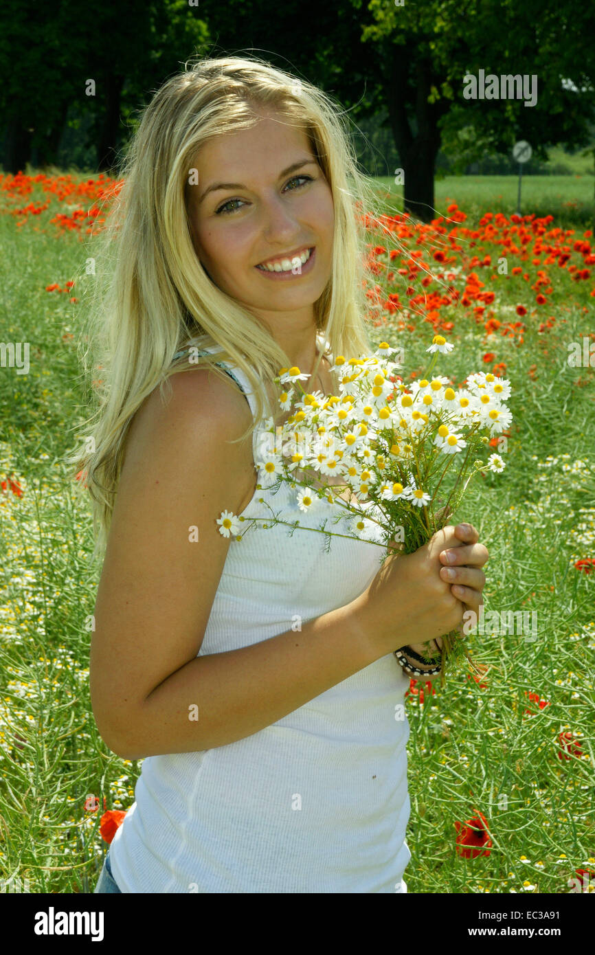 woman with flowers at a field Stock Photo