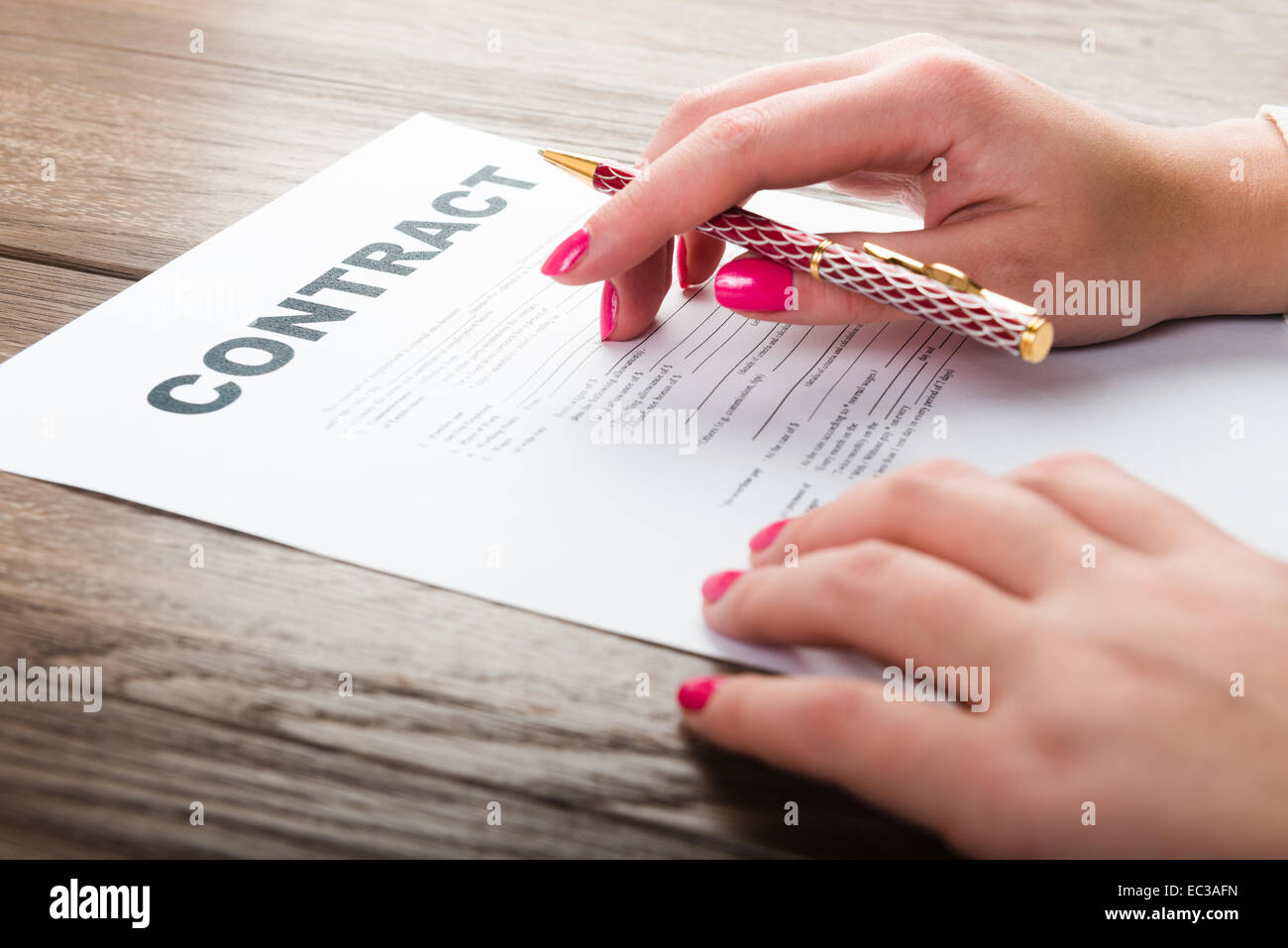 Businesswoman's hand with pen signing a contract Stock Photo - Alamy