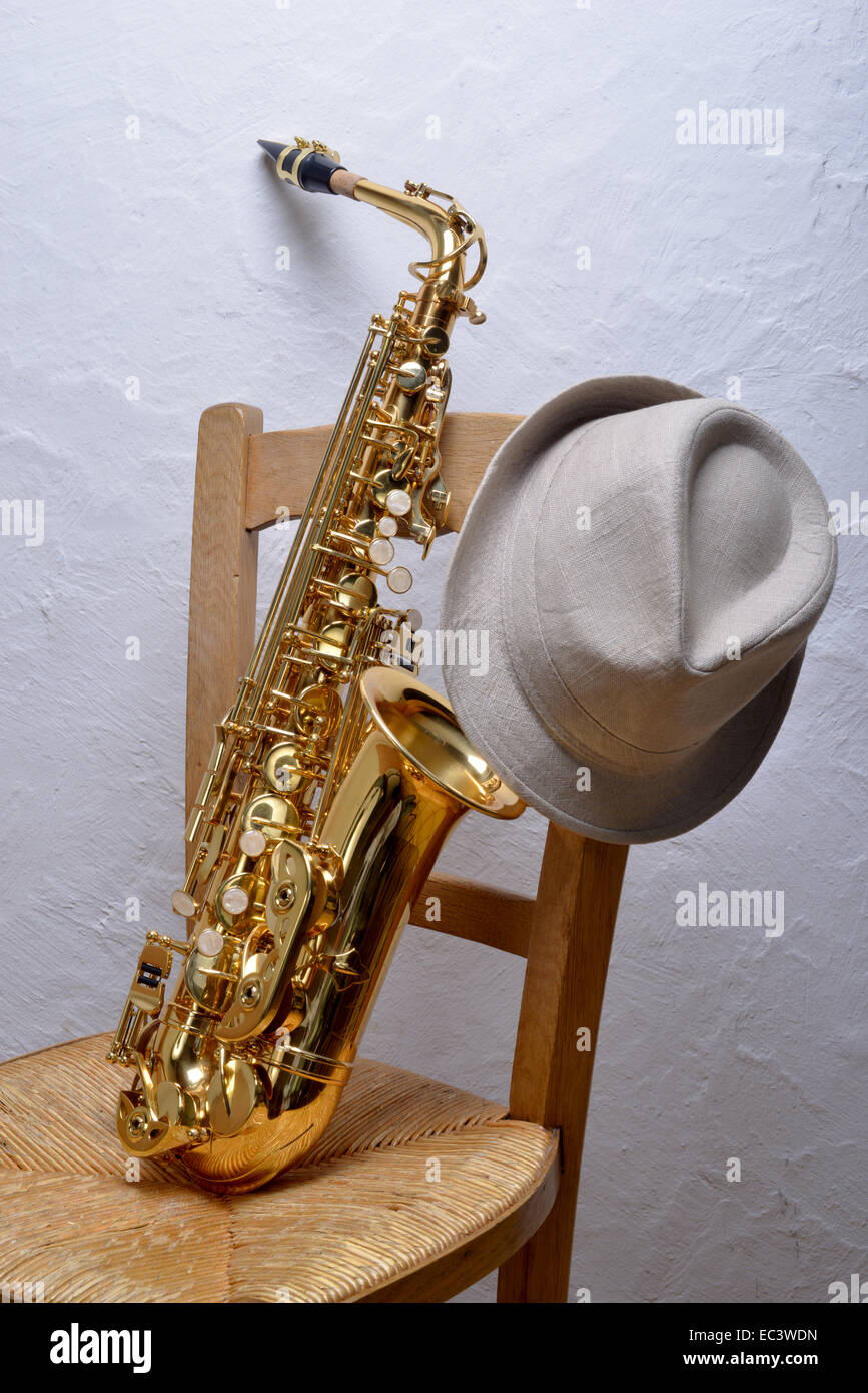 saxophone on a chair with a hat Stock Photo