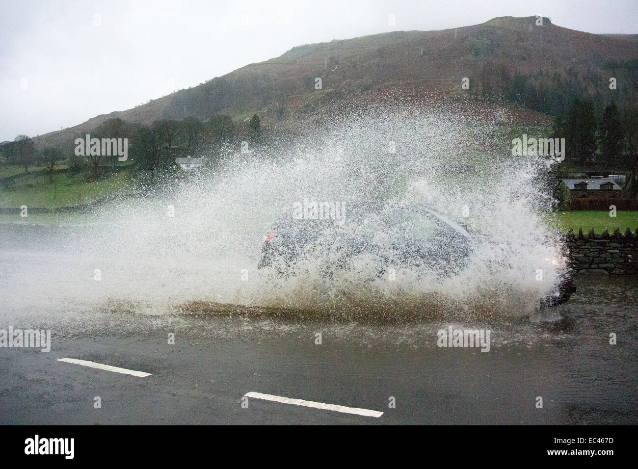 Traffic on the A591 at Grasmere in the English Lake District had to endure floods of water on the road. This stretch of road bet Stock Photo