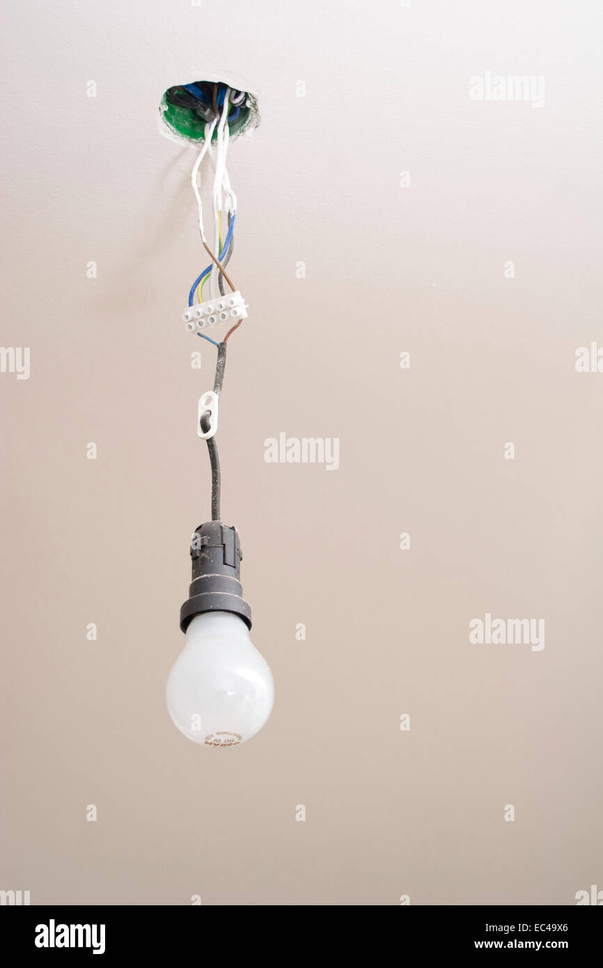 Light Bulb In Lamp Socket Hanging From Ceiling Stock Photo