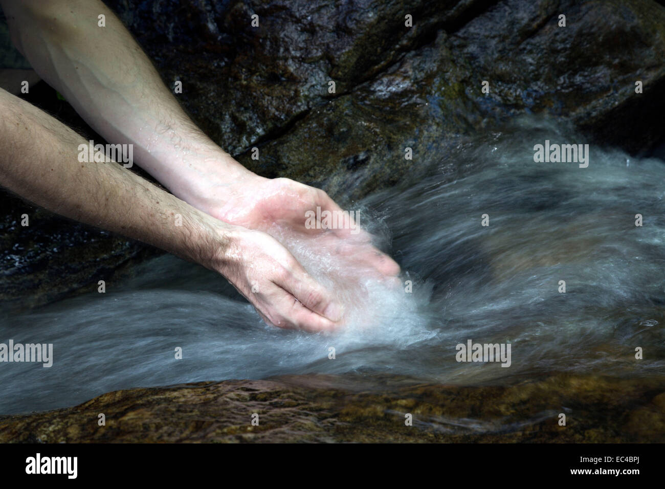 wahing hands in a stream Stock Photo