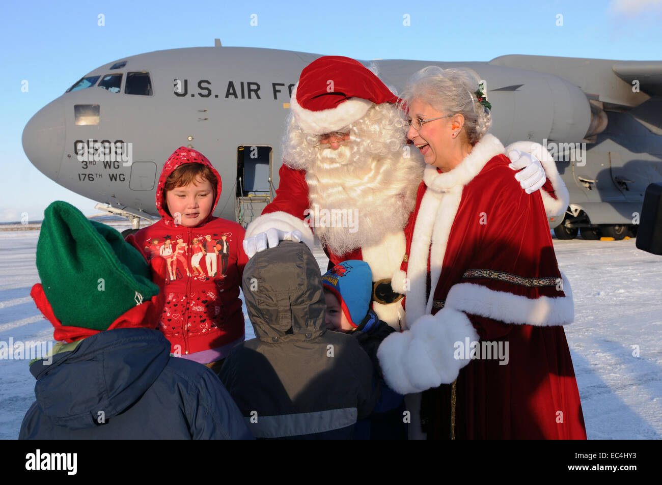 Santa Claus and Mrs. Claus greet children after arriving to a visit a remote Aleut native village as part of Operation Santa Claus November 6, 2010 in St. Paul Island, Alaska. Operation Santa Claus has delivered donated gifts to poor remote Alaskan villages by Air Force transport since 1951. Stock Photo