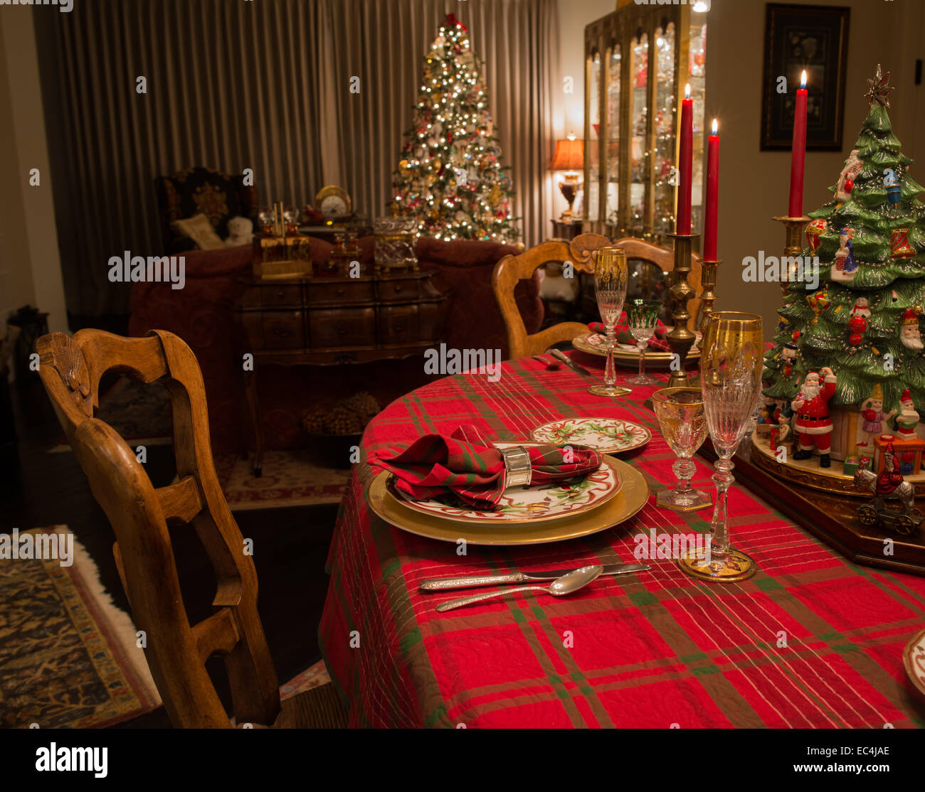 Set Christmas dinner table with Christmas tree in background Stock Photo