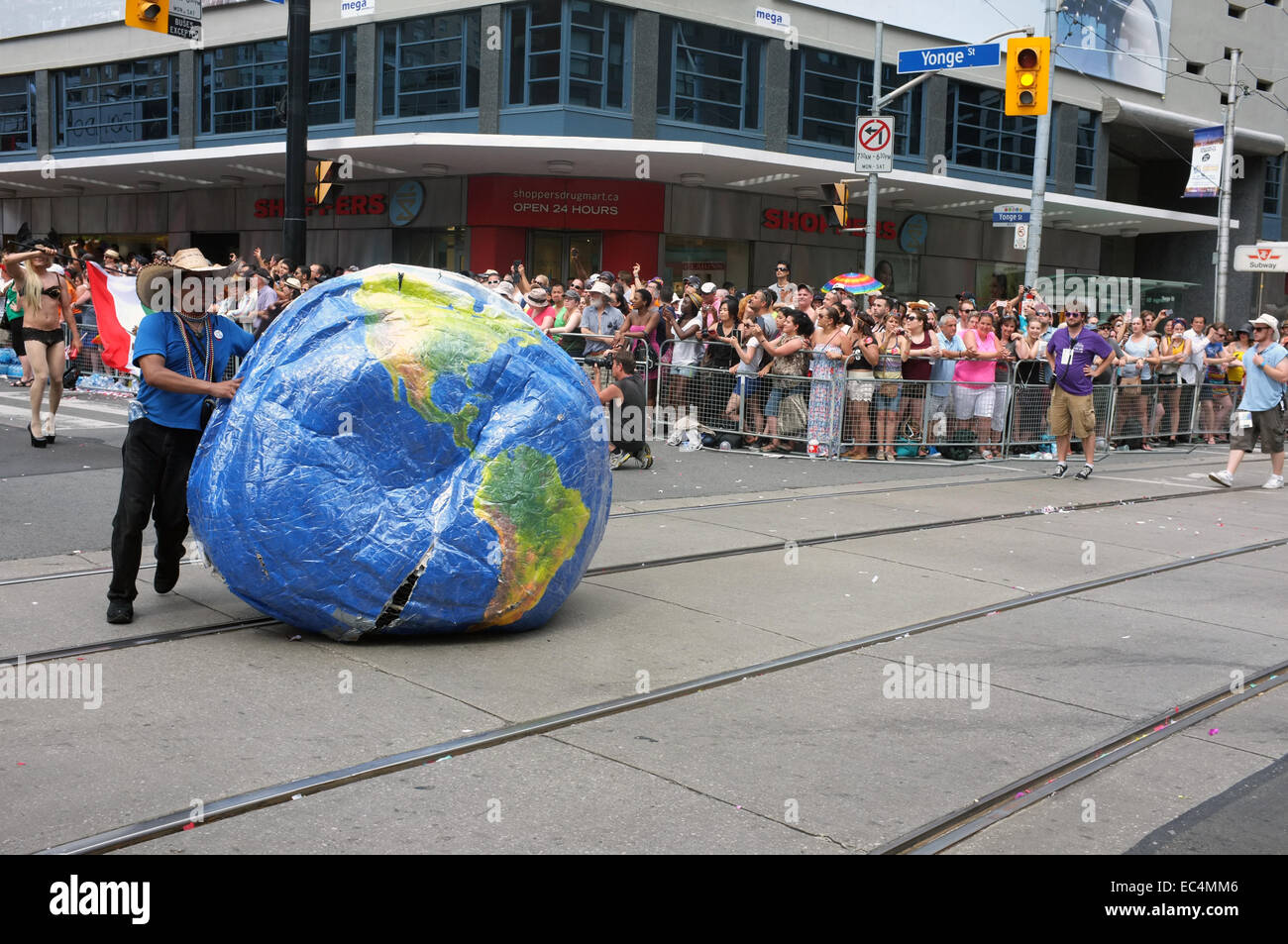 A man pushes an inflatable globe at the 2014 World Pride in Toronto. Stock Photo