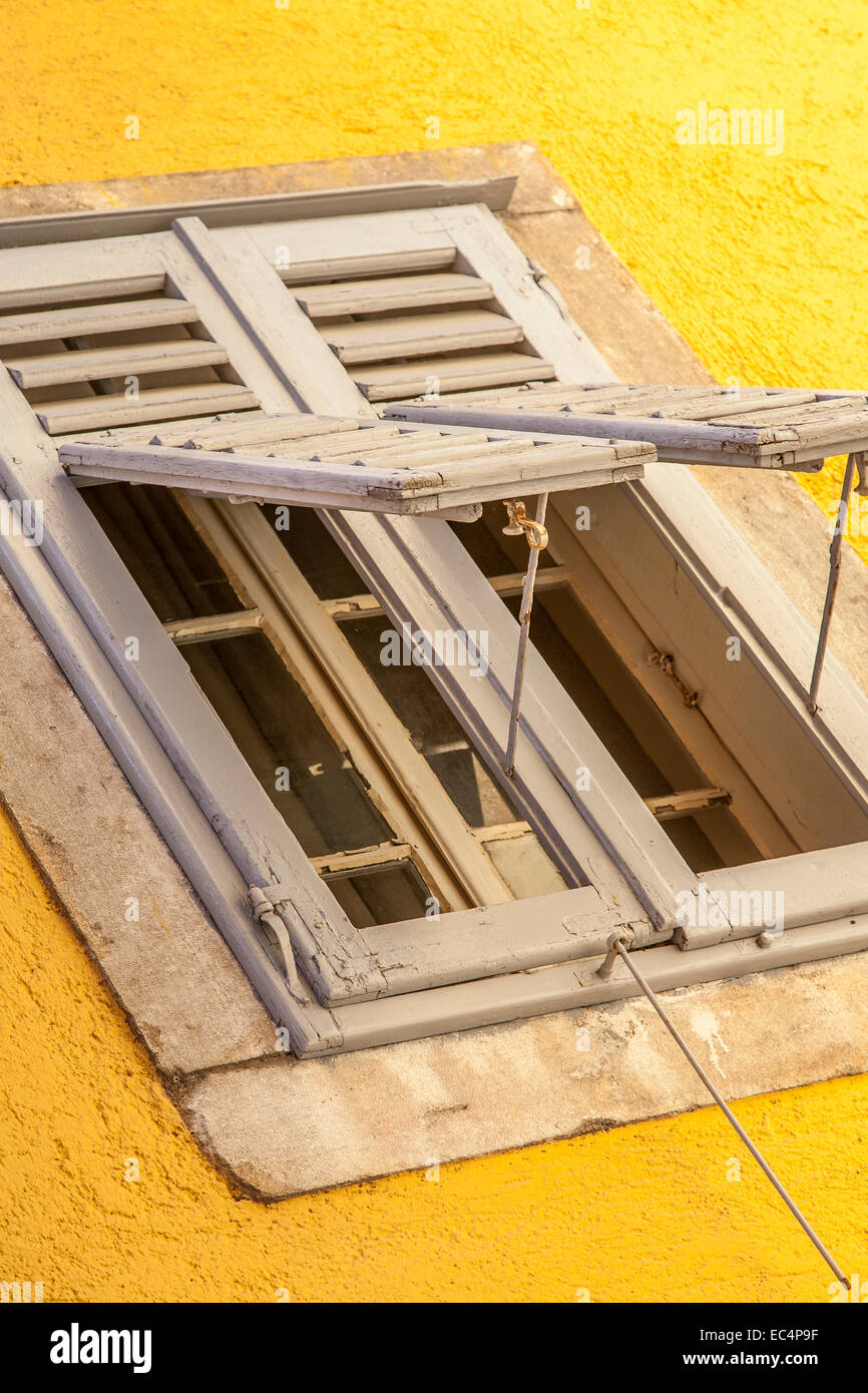 Window with shutters on yellow house Stock Photo