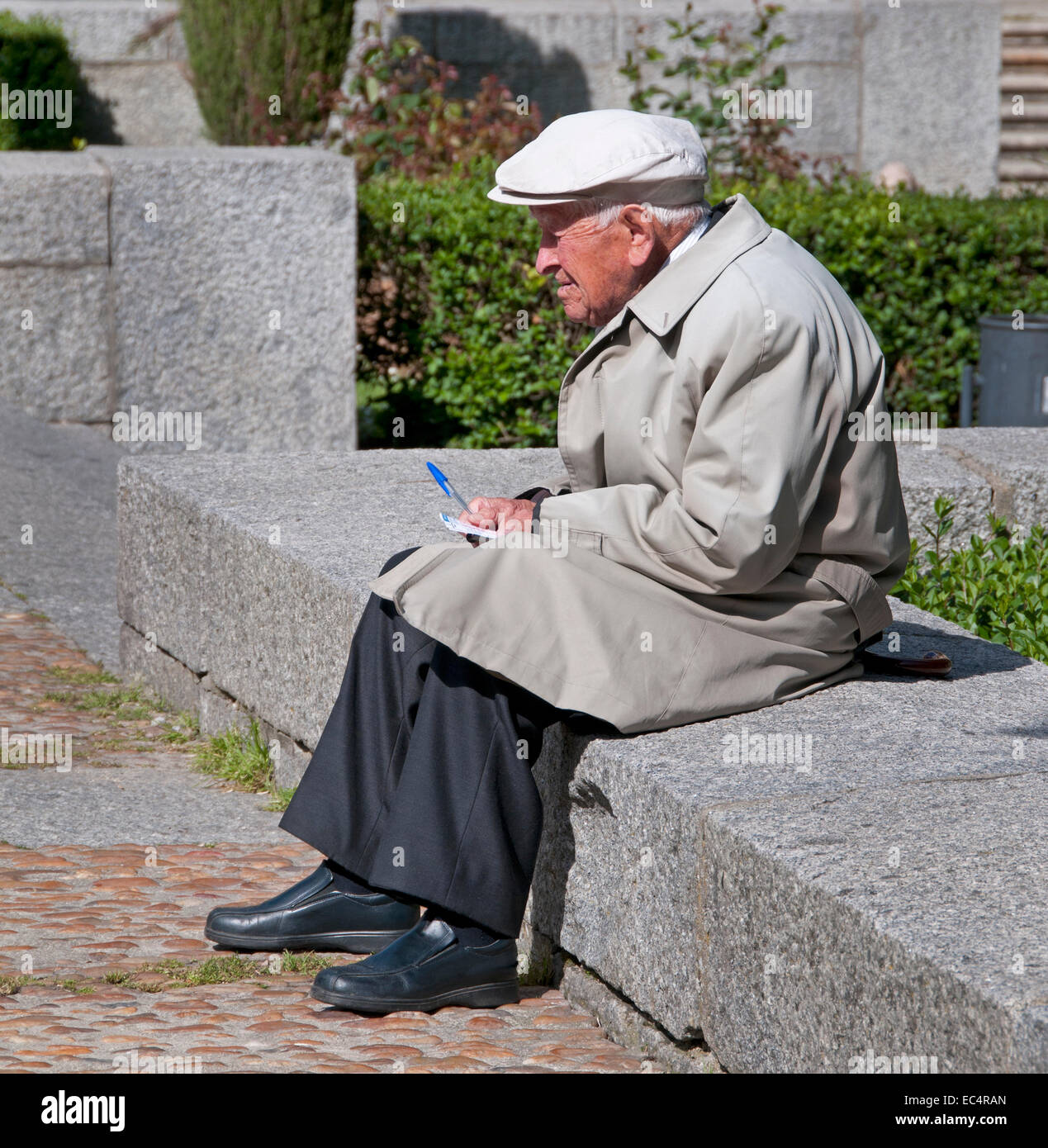 Old Man writing in the Sun in front of University  Salamanca old town center ( Castile and Leon ) Spain Spanish Stock Photo