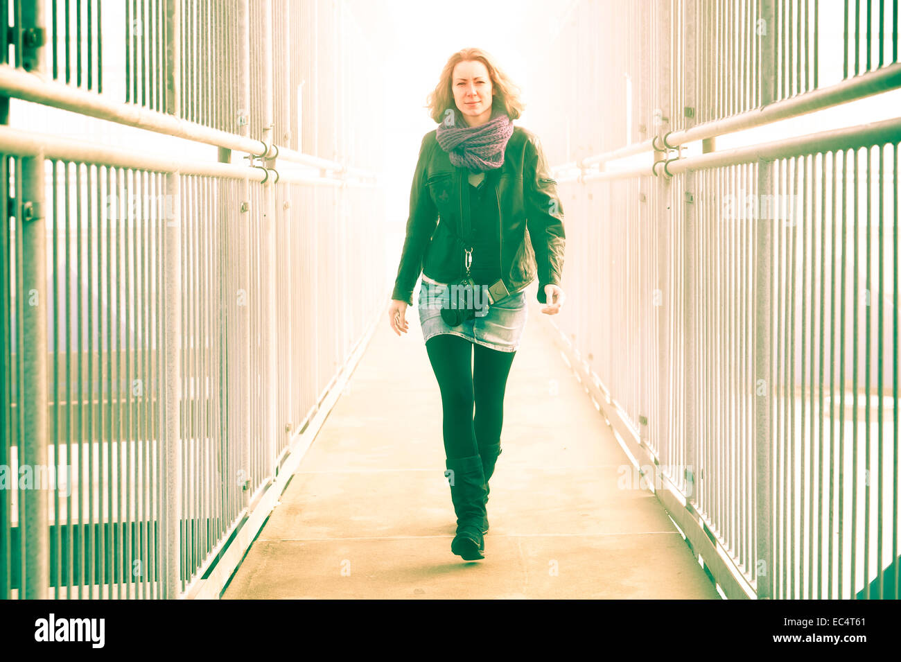 young woman on a path between two metal fences Stock Photo