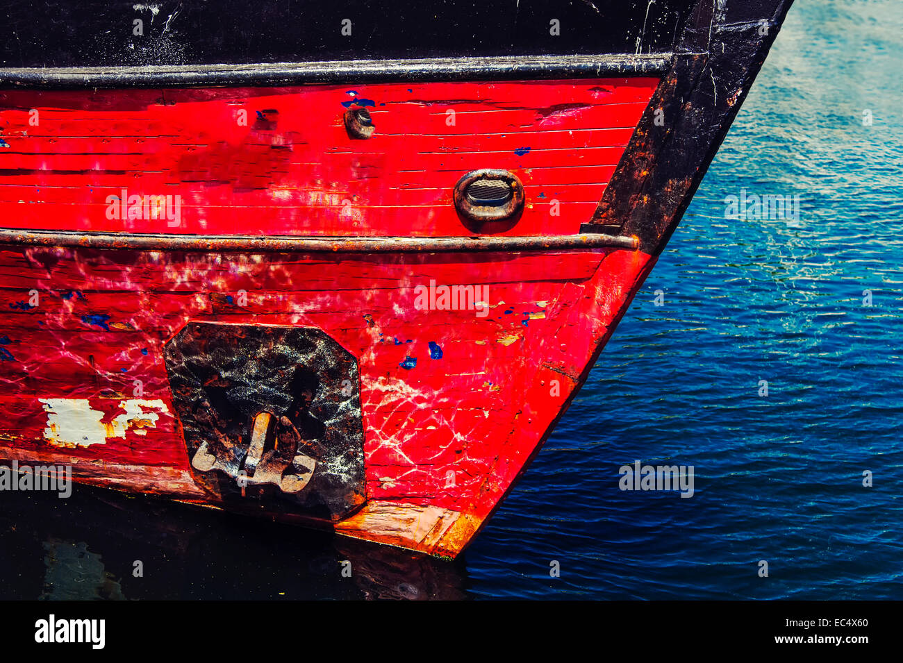 Prow of a ship s red against blue water Stock Photo