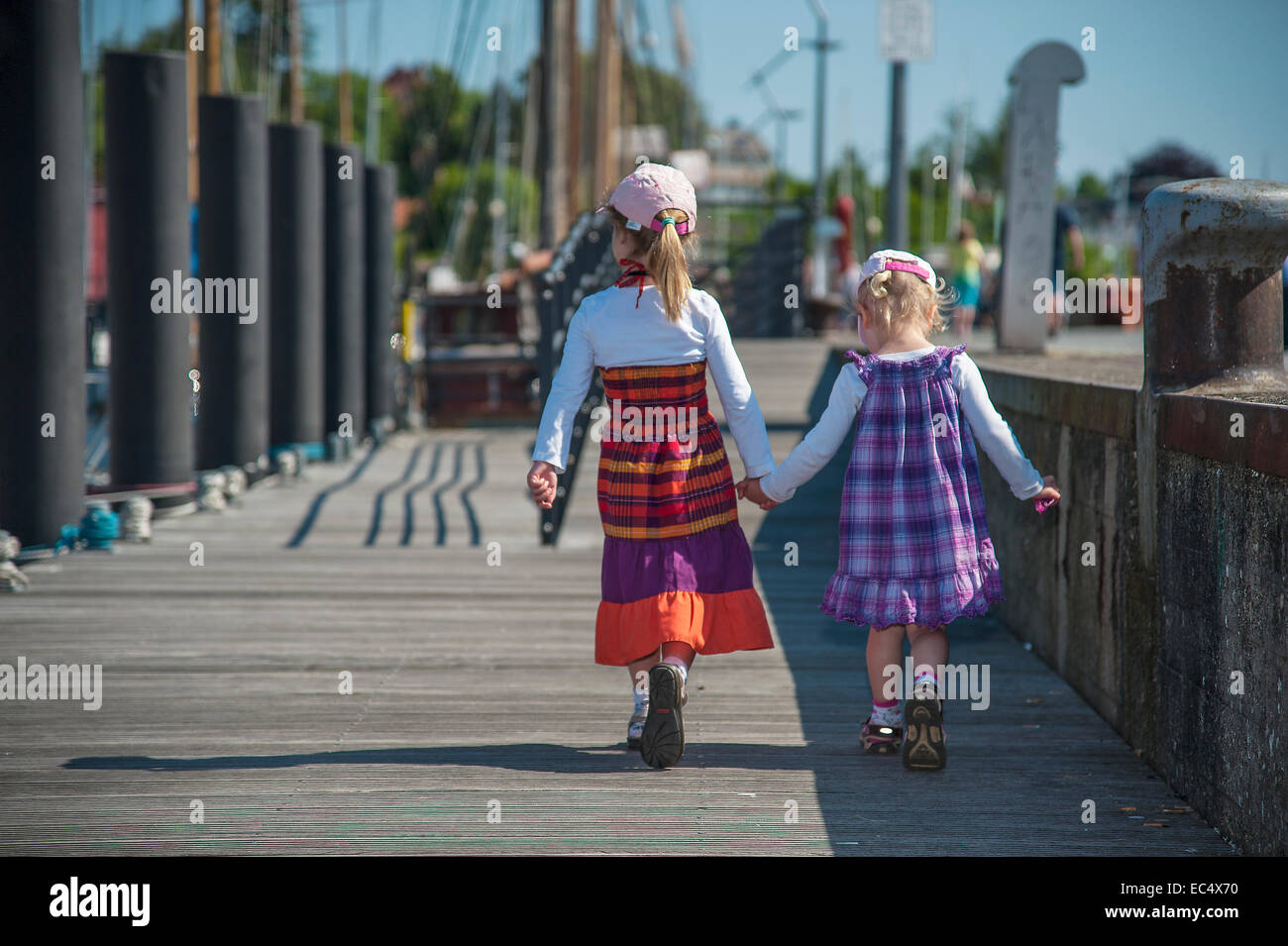 2 little girls walking hand in hand Stock Photo - Alamy