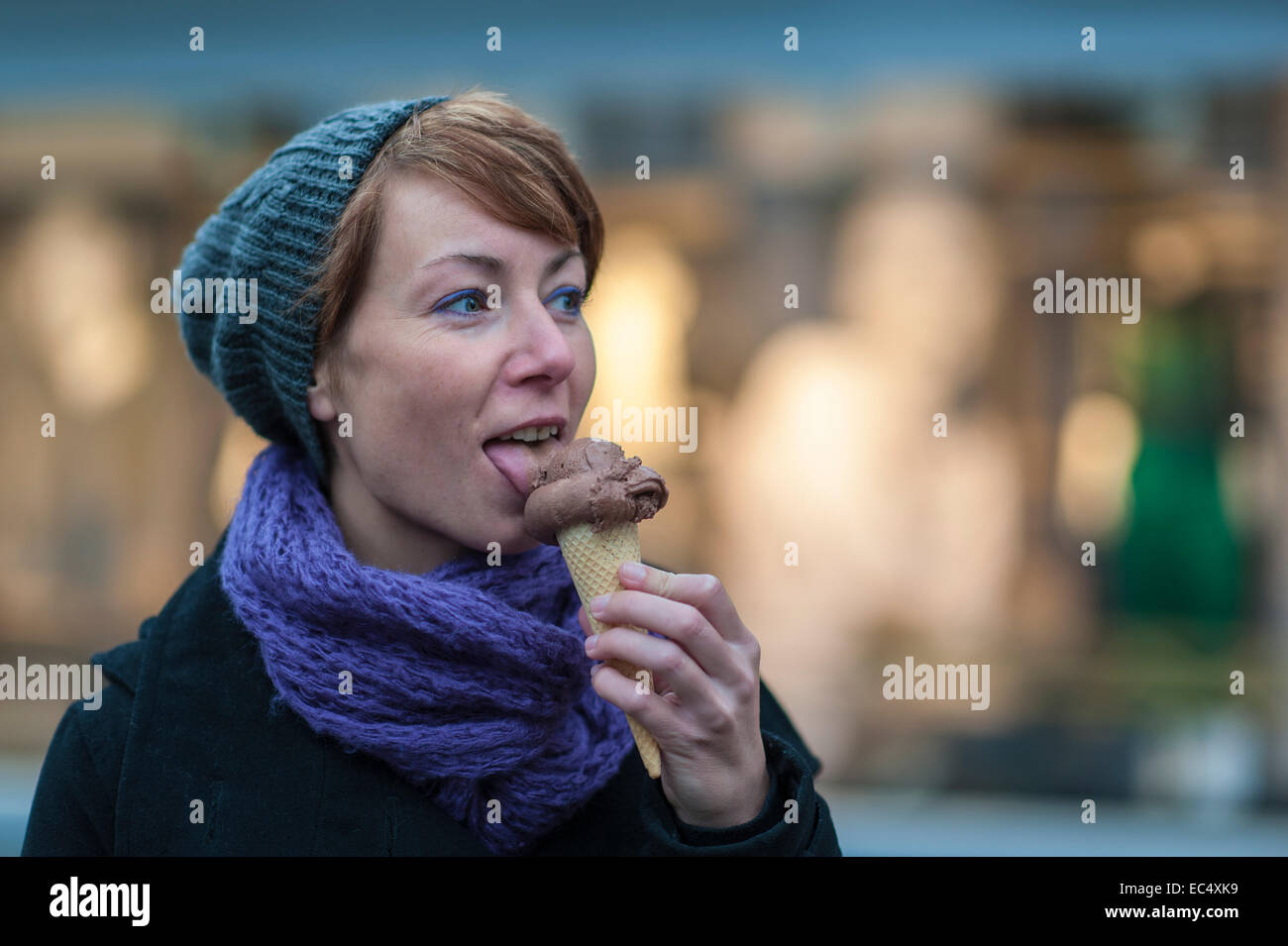 a young woman licks an ice cream cone Stock Photo