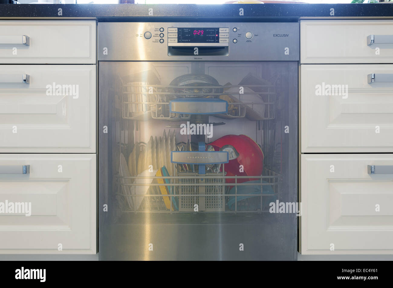 dishwasher filled with transparent flap Stock Photo Alamy