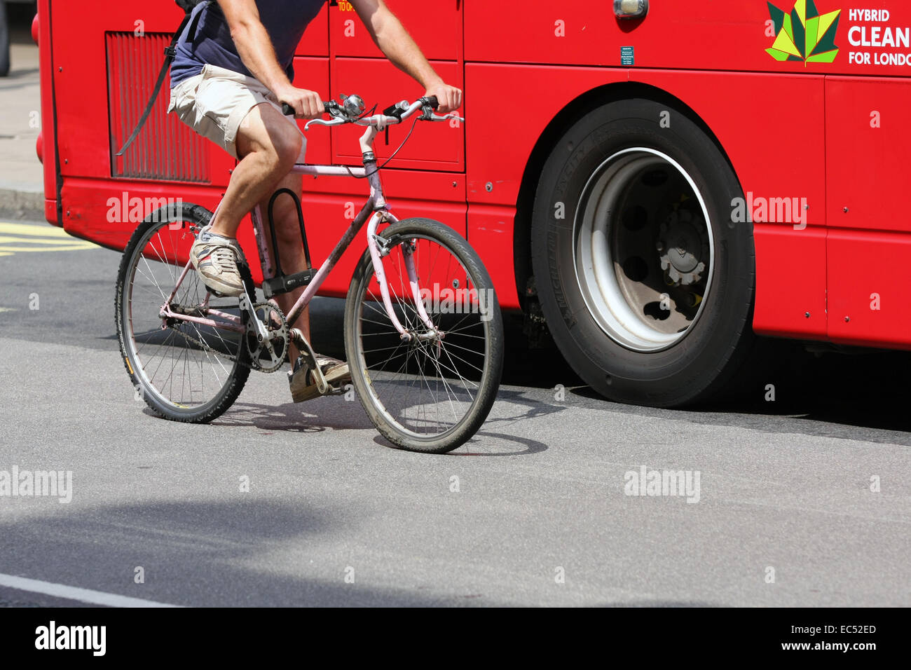 A cyclist passing a London bus waiting at a bus stop in Oxford Street ...