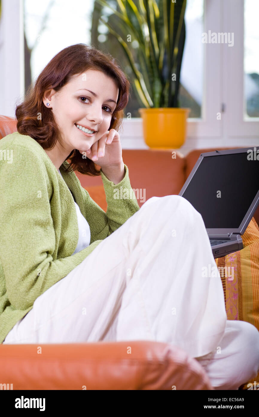 a young woman with the laptop on the sofa Stock Photo - Alamy