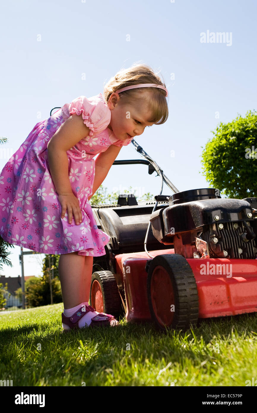 a 3,5 years old girl working in the garden Stock Photo