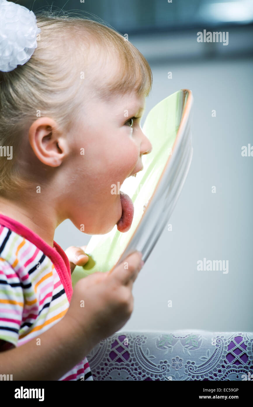 a 4 years old girl licking a plate Stock Photo Alamy