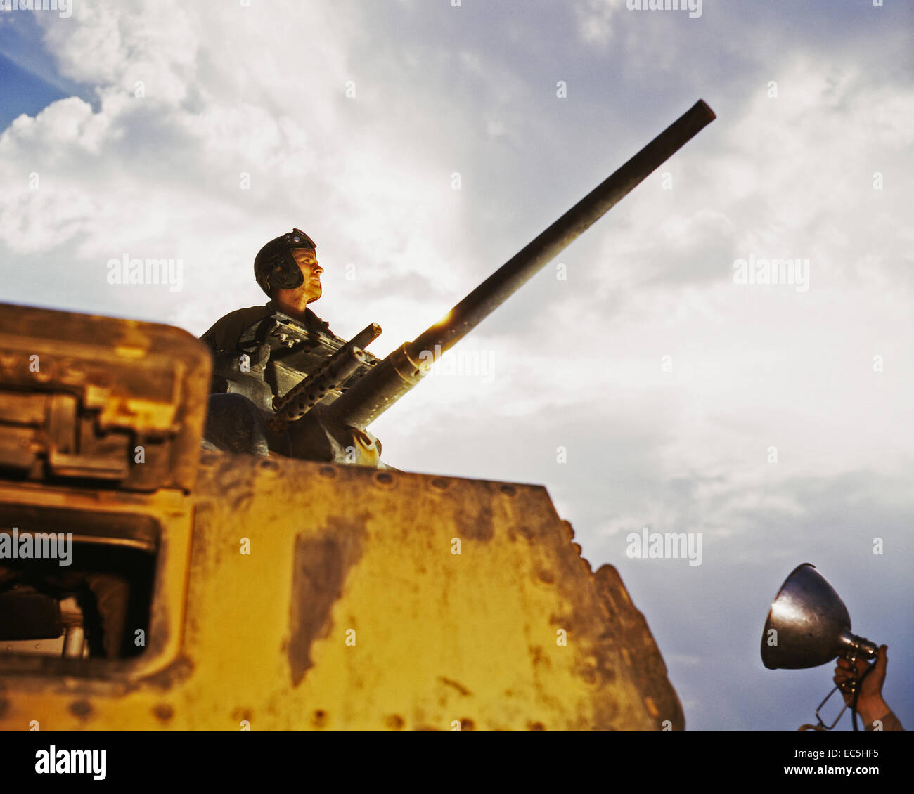 M-4 tank commander, Ft. Knox, Ky.  A soldier holding the photographer's floodlight appears at bottom right. June, 1942. Photograph By Alfred T. Palmer Stock Photo