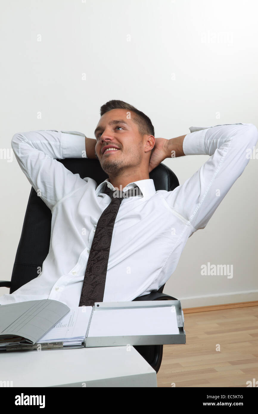 Satisfied young man sitting hi-res stock photography and images - Alamy