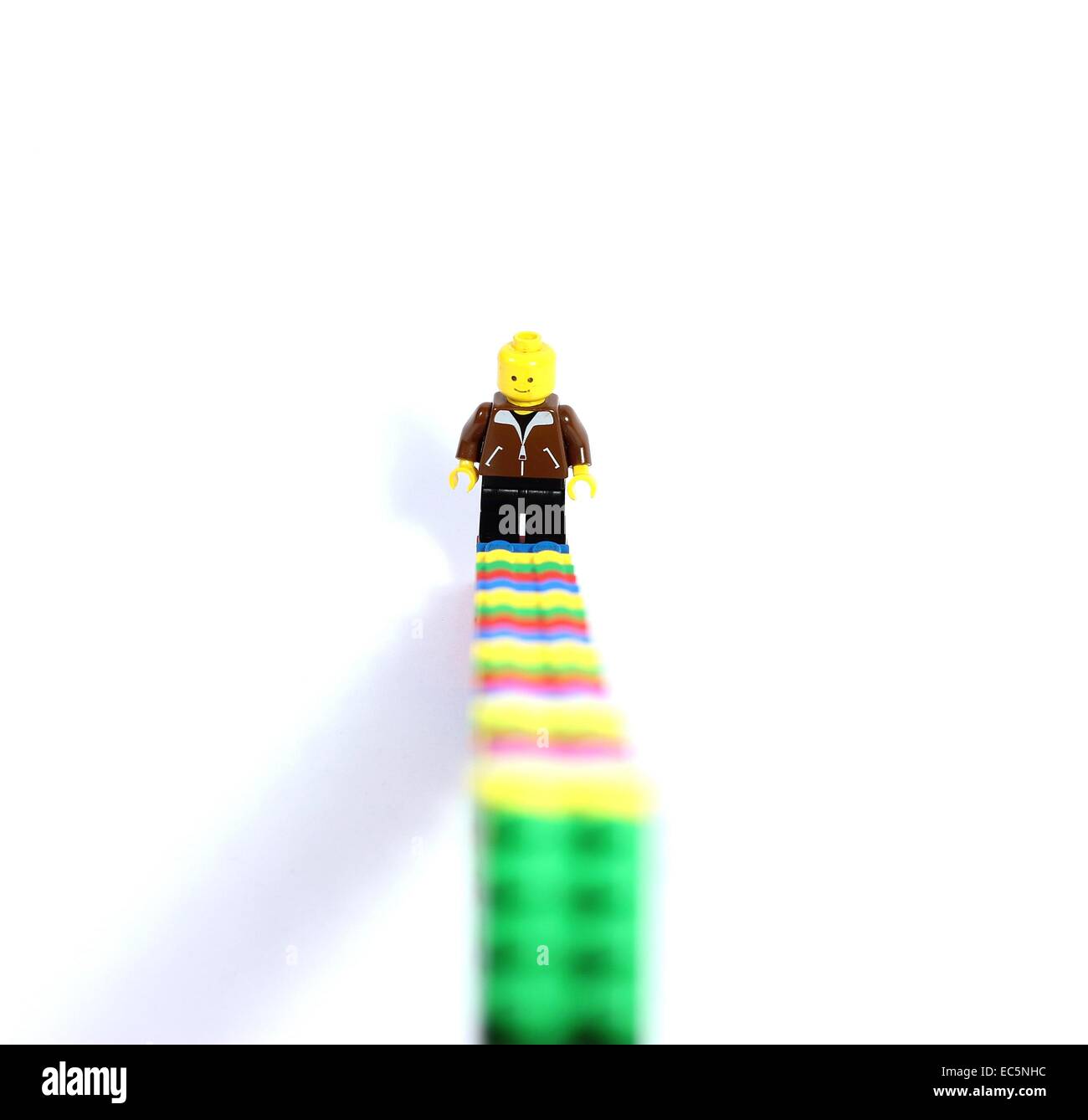 Lego figure and lego stairs. Rising. Smiling at difficulties. Stock Photo