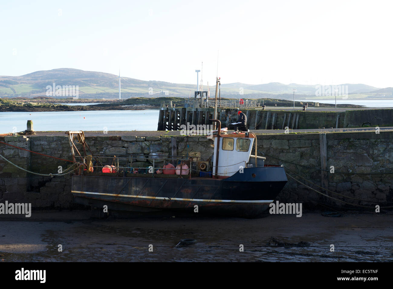 An artist sits on the harbour painting, Millport, Cumbrae. Stock Photo