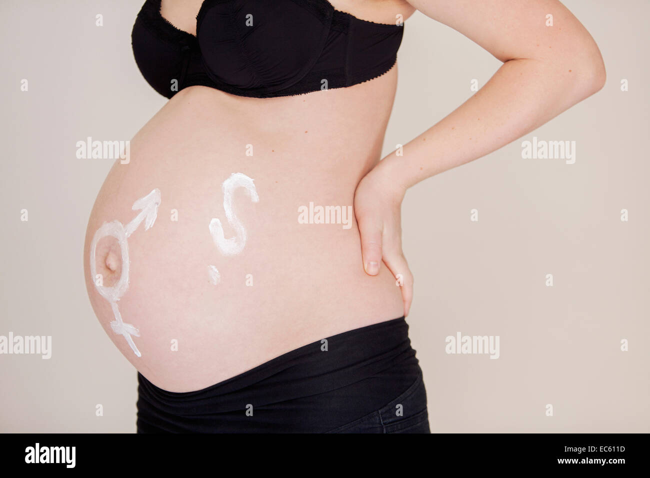 Pregnant young woman deliberates whether it is a boy or girl belly baby bump expectant mother pregnancy surprise feminine Stock Photo