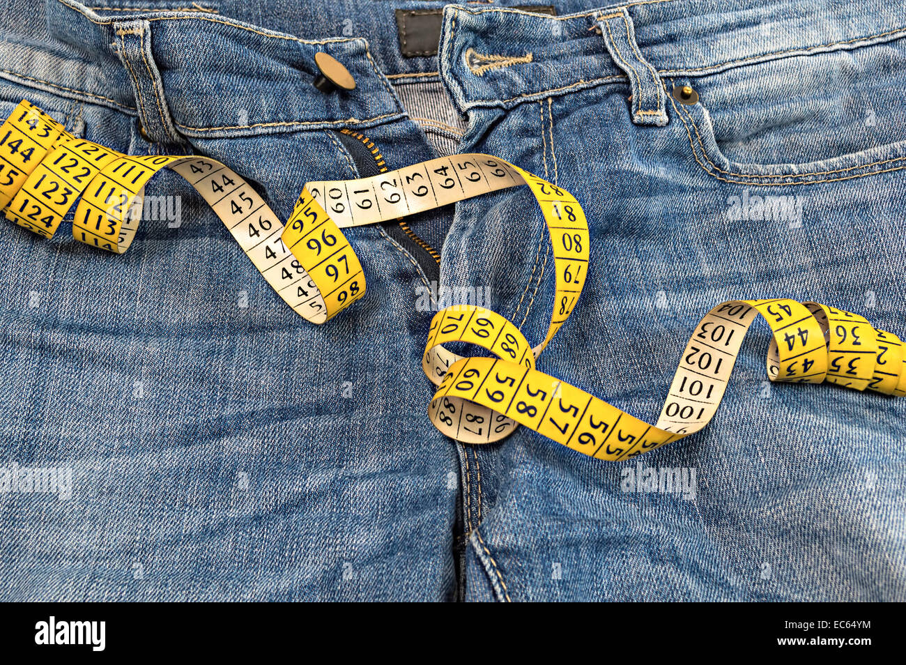 Detail of blue jeans with measuring tape. Stock Photo