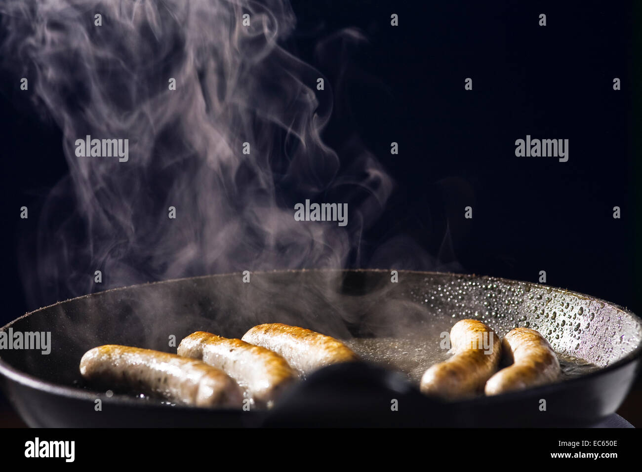 frying sausage in a pan Stock Photo