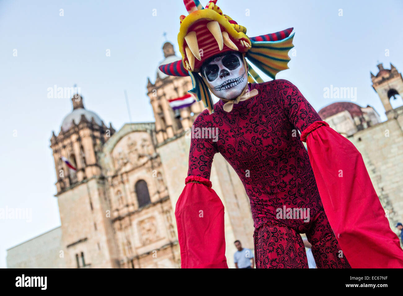 A young man dressed as a skeleton on circus stilts outside the Santo