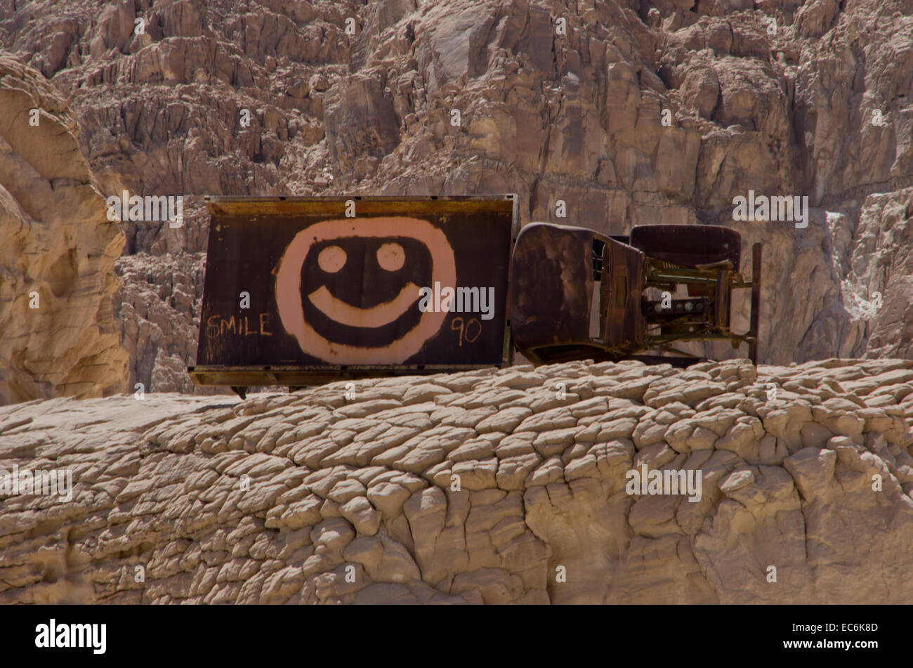 Car wreck with smiley in the desert without a motor Stock Photo