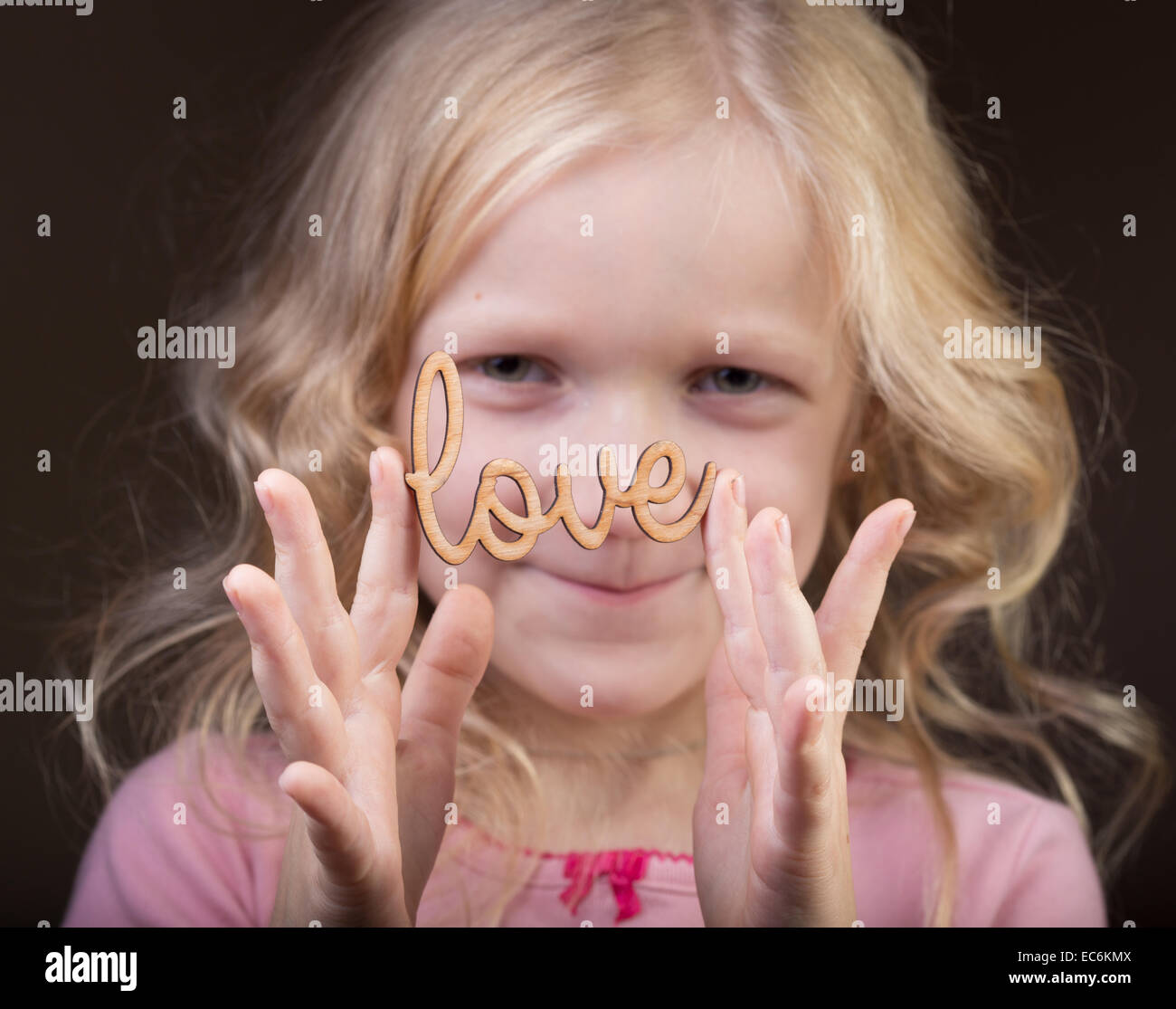 little girl holding a word Love at her hands Stock Photo - Alamy