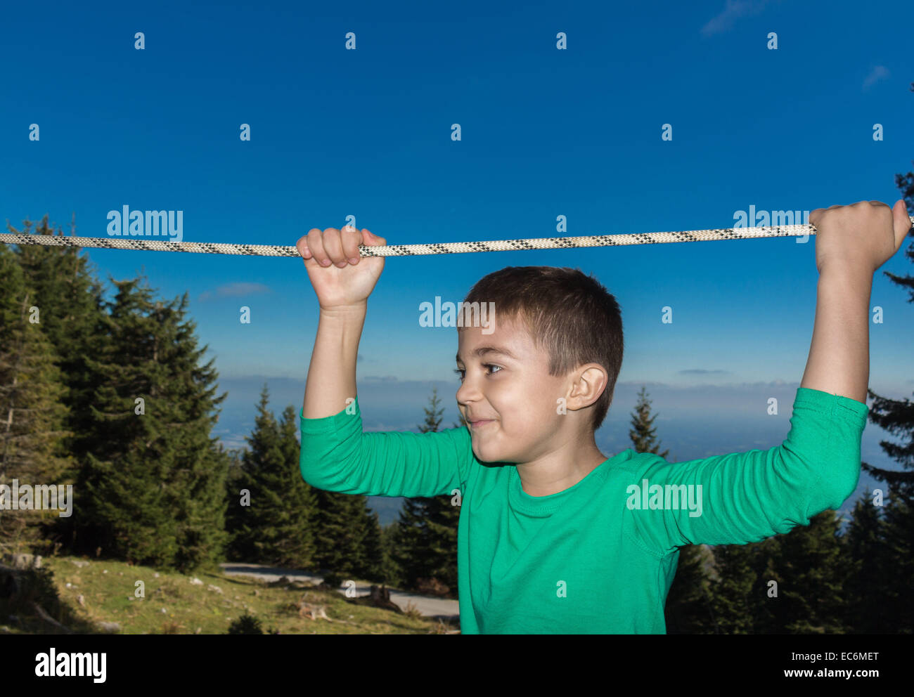 8 year old child climbing trees in The Austrian Alps Stock Photo