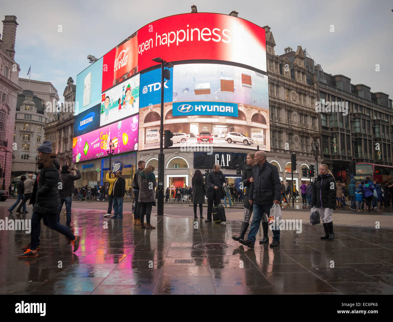 Pedestrians walk on a wet pavement in Piccadilly Circus, London, England Stock Photo